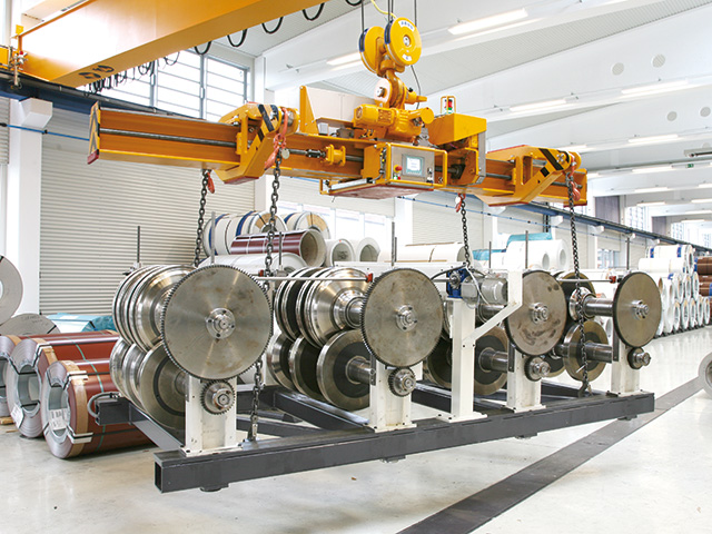 Spreader for transporting roll forming racks